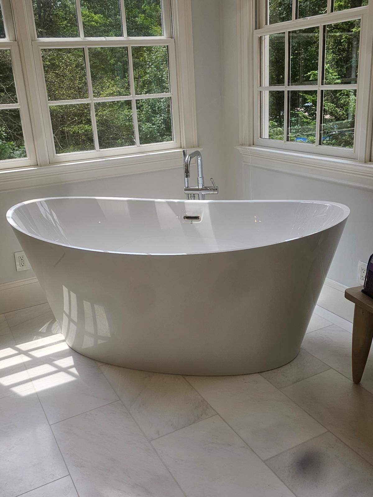 Freestanding tub near large windows